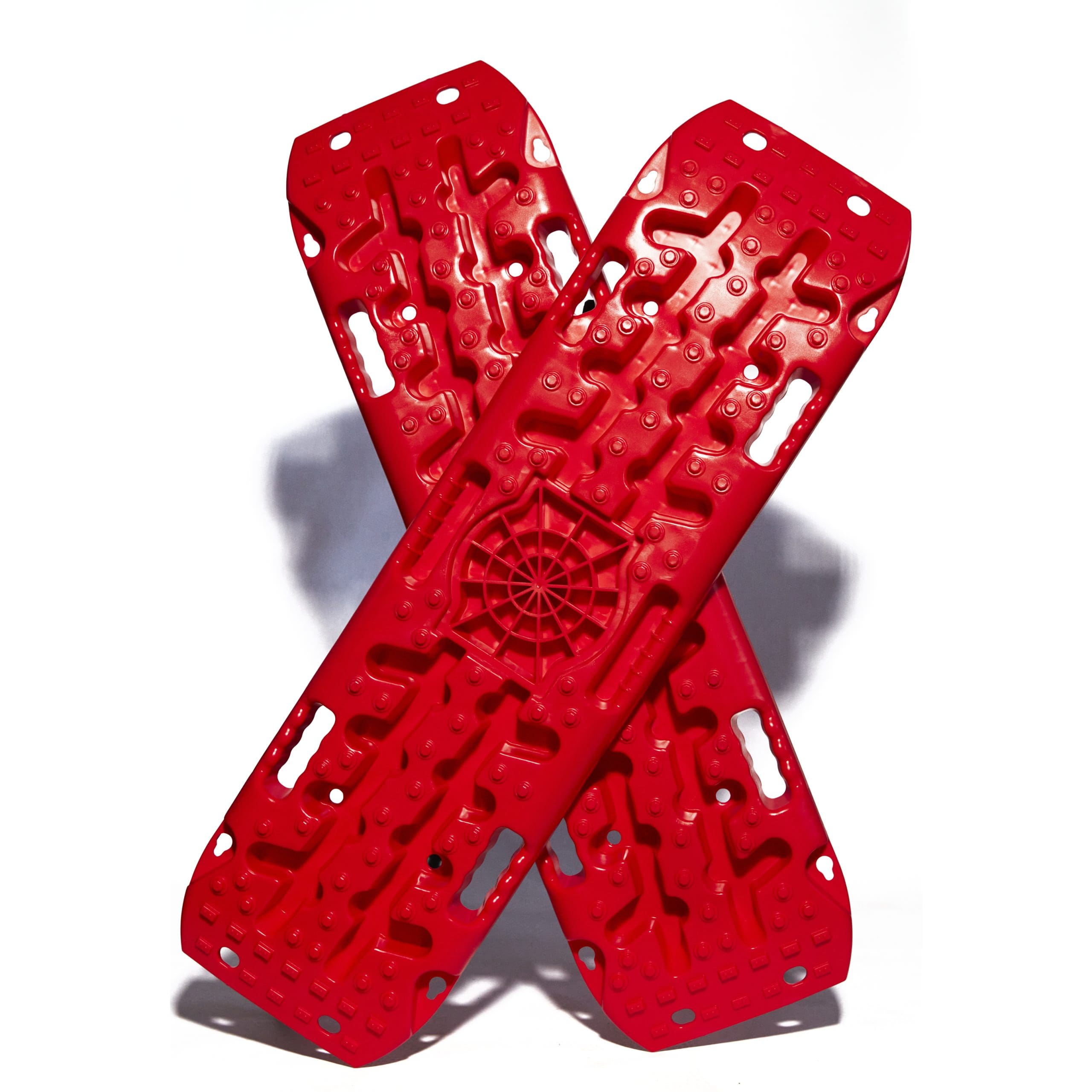 The two red Way-Out Traction Boards by OmegaStrap® are arranged in a crisscross pattern against a white background, highlighting their textured surfaces and demonstrating their outstanding grip and durability. - OmegaStrap - World's Greatest Ratchet Strap